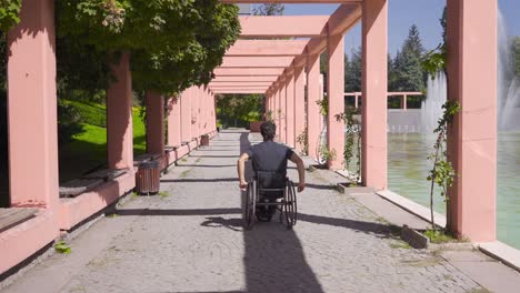Disabled-young-man-is-walking-down-the-street-in-his-wheelchair.